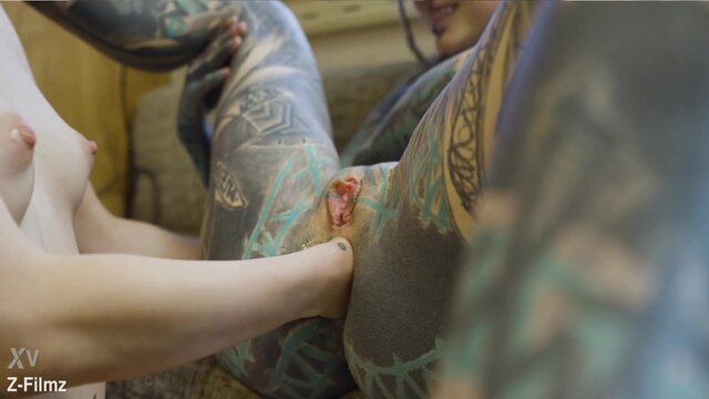 Petite tattooed blonde plays with enormous dildos in girl-on-girl action